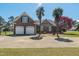 Charming brick home with a well-manicured front yard, palm trees and a spacious driveway leading to a two-car garage at 1055 Tilghman Rd, Dunn, NC 28334