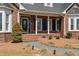 Inviting front porch with brick steps and columns, complemented by manicured landscaping, and decorative front door at 1055 Tilghman Rd, Dunn, NC 28334