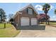 Side view of home's brick garage with driveway and palm trees in view at 1055 Tilghman Rd, Dunn, NC 28334
