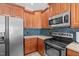 Kitchen features wood cabinetry, stainless steel appliances, and blue tile backsplash at 1055 Tilghman Rd, Dunn, NC 28334
