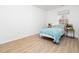 Bright bedroom with a large window, light wood flooring, and a bed dressed in a light blue comforter at 106 Mingocrest Dr, Knightdale, NC 27545