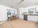 Bright kitchen with white cabinets, stainless steel appliances, wood floors, and a dining area at 106 Mingocrest Dr, Knightdale, NC 27545