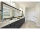 Spacious bathroom featuring double sinks, granite countertops, and a large mirror at 1113 Cryptic Wood Ave, Fuquay Varina, NC 27526
