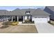 Charming single-story home with a covered porch and well-manicured front yard and two car garage at 1113 Cryptic Wood Ave, Fuquay Varina, NC 27526