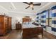 Charming bedroom featuring hardwood floors, a ceiling fan, and natural light from the large windows at 1113 Cryptic Wood Ave, Fuquay Varina, NC 27526