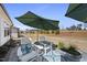 Outdoor patio featuring Adirondack chairs, outdoor umbrella, and blue patterned rug at 1113 Cryptic Wood Ave, Fuquay Varina, NC 27526