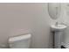 A half bathroom featuring a pedestal sink and toilet in a modern setting at 1113 Ursa Major Ct, Wendell, NC 27591