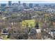 Expansive aerial view of a neighborhood with a distant city skyline and mature trees in the background at 1121 Parkridge Ln # 207, Raleigh, NC 27605