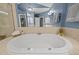 This bathroom features a tile floor, soaker tub, and large mirror at 116 Arlen Park Pl, Holly Springs, NC 27540