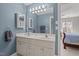 This bathroom features a double vanity sink, mirror, and a view into the main bedroom at 116 Arlen Park Pl, Holly Springs, NC 27540