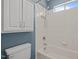 This bathroom features white tiled walls, a showerhead, a bathtub, and a set of shelves at 116 Arlen Park Pl, Holly Springs, NC 27540