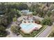 An aerial view showcases the community pool surrounded by lush trees and foliage at 116 Arlen Park Pl, Holly Springs, NC 27540