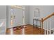 Inviting foyer features hardwood floors, a transom window, and natural light with a decorative console table and mirror at 116 Arlen Park Pl, Holly Springs, NC 27540
