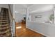 Bright entryway featuring hardwood floors, staircase with patterned runner, and an open view to the dining area at 116 Arlen Park Pl, Holly Springs, NC 27540
