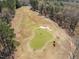 Scenic aerial view of the golf course with a lush green putting green and sand traps at 116 Arlen Park Pl, Holly Springs, NC 27540