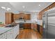 Well-equipped kitchen with stainless steel appliances, custom cabinetry, granite countertops and hardwood floors at 116 Arlen Park Pl, Holly Springs, NC 27540
