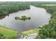 An aerial view reveals a picturesque lake with a tree-covered island and boat docks at 116 Arlen Park Pl, Holly Springs, NC 27540