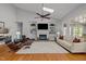Bright living room with built-in shelving around a fireplace, hardwood floors, and comfortable seating at 116 Arlen Park Pl, Holly Springs, NC 27540