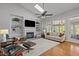 Bright living room with fireplace, built-in shelves, hardwood floors, and comfortable seating creates an inviting space at 116 Arlen Park Pl, Holly Springs, NC 27540