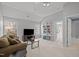 This living room features a sofa, a television, built-in shelves, and a view into the bathroom at 116 Arlen Park Pl, Holly Springs, NC 27540