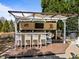 Covered outdoor bar featuring counter seating, a built-in TV, and wooded views at 116 Arlen Park Pl, Holly Springs, NC 27540