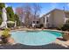 A freeform backyard pool and patio features outdoor seating and mature landscaping at 116 Arlen Park Pl, Holly Springs, NC 27540