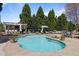 Backyard pool with an outdoor bar, lounge seating, and tall trees for privacy at 116 Arlen Park Pl, Holly Springs, NC 27540