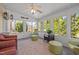 Sunroom with many windows providing natural light, a ceiling fan, and views of the private landscaped backyard at 116 Arlen Park Pl, Holly Springs, NC 27540