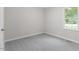 Neutral bedroom with gray carpeting and a window overlooking the trees in the backyard at 1209 Freeman Dr, Sanford, NC 27330