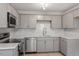 Modern kitchen features gray cabinets, stainless steel appliances, and light tile backsplash at 1209 Freeman Dr, Sanford, NC 27330