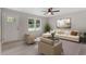 Bright living room with neutral décor, ceiling fan, and abundant natural light from large front-facing window at 1209 Freeman Dr, Sanford, NC 27330