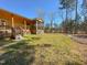 Exterior view of home with a wood back porch and screened-in area, set against a spacious backyard at 1220 E Middleton Dr, Creedmoor, NC 27522