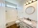 Bathroom featuring granite counters, white cabinets, updated fixtures, and a shower-tub combo at 1220 E Middleton Dr, Creedmoor, NC 27522