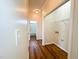 Hallway with hardwood floors, laundry closet with hookups, and a view into the bathroom at 1220 E Middleton Dr, Creedmoor, NC 27522