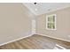 Neutral bedroom featuring wood-look flooring, a large window, and recessed lighting at 133 Mohawk Dr, Louisburg, NC 27549