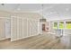 Open-concept living area with wood floors, decorative wall, and view of the kitchen and fireplace at 133 Mohawk Dr, Louisburg, NC 27549