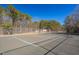 A tennis court surrounded by mature trees, offering a private and scenic recreational area for active residents to enjoy at 133 Mohawk Dr, Louisburg, NC 27549