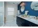 Elegant bathroom with marble counters, double sinks, dark blue accent wall, and a glass shower at 1403 Copper Cir, Mebane, NC 27302