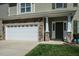 Close-up of a charming home showcasing a stone accent garage, and a well-manicured front lawn at 1403 Copper Cir, Mebane, NC 27302