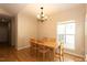 Bright dining room featuring hardwood floors, natural light from the window, and a modern light fixture at 1503 Orchard Villas Ave, Apex, NC 27502
