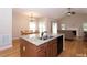 Open-concept kitchen with a breakfast bar island, stainless steel sink, and views into the living room at 1503 Orchard Villas Ave, Apex, NC 27502