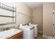 Bright laundry room featuring modern washer and dryer, sink, granite countertops, and shelving at 1503 Orchard Villas Ave, Apex, NC 27502
