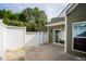Back patio featuring a white fence, lush greenery, and a sliding glass door leading inside at 1503 Orchard Villas Ave, Apex, NC 27502