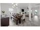 Open-concept dining area features a large wooden table, stylish chandelier, and view into the living space at 151 Kutter Dr, Elon, NC 27244