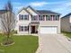 Charming two-story home with a well-manicured lawn, attached two-car garage and complementary landscaping at 151 Kutter Dr, Elon, NC 27244