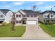 Charming two-story home with a well-manicured lawn, attached two-car garage and complementary landscaping at 151 Kutter Dr, Elon, NC 27244