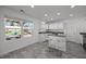 Bright kitchen features white cabinets, an island with seating, and a window with a view of the outdoor patio at 151 Kutter Dr, Elon, NC 27244