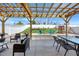 A backyard patio area featuring a pergola, a fire pit with chairs, and a playground in a fenced yard with lush grass at 151 Kutter Dr, Elon, NC 27244