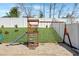 A charming backyard playground featuring a slide, climbing wall, and swingset for outdoor enjoyment in a fenced in area at 151 Kutter Dr, Elon, NC 27244
