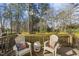Charming wooden deck with chairs and a table, surrounded by lush trees and greenery at 1720 Highpoint St, Wake Forest, NC 27587